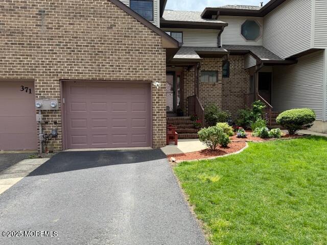 372 Oak Knoll Dr, Manalapan, NJ 07726 - view of front of house featuring brick siding, asphalt driveway, a front lawn, and a garage