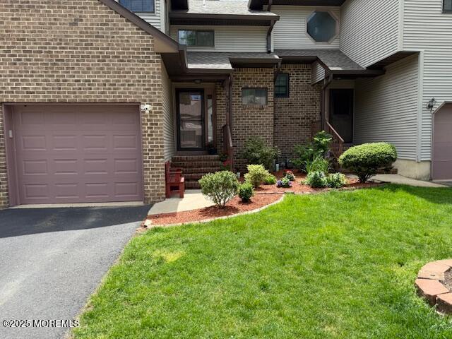 372 Oak Knoll Dr, Manalapan, NJ 07726 - entrance to property featuring brick siding, a yard, driveway, and an attached garage