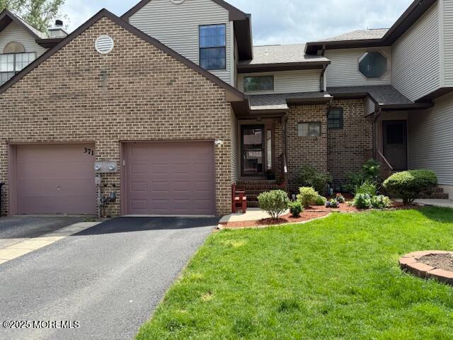372 Oak Knoll Dr, Manalapan, NJ 07726 - view of front of home with brick siding, driveway, a front yard, and a garage