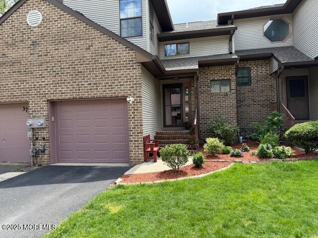 372 Oak Knoll Dr, Manalapan, NJ 07726 - view of front of home with brick siding, driveway, a front lawn, and an attached garage