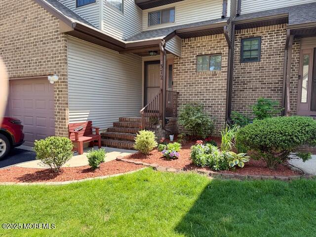 372 Oak Knoll Dr, Manalapan, NJ 07726 - property entrance featuring brick siding, a garage, and a yard