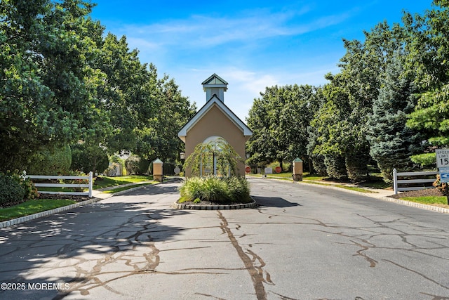 37 Violet Ct, Holmdel, NJ 07733 - view of asphalt road with curbs and a gated entry