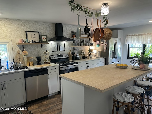 45 Cathy Ct, Jackson, NJ 08527 - kitchen featuring stainless steel appliances, wall chimney exhaust hood, light countertops, a kitchen bar, and open shelves
