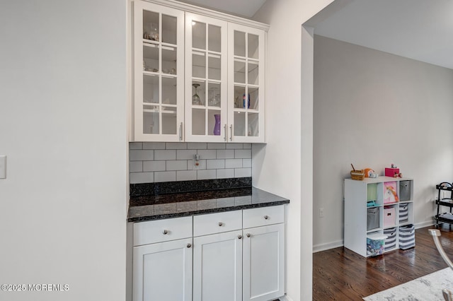 909 Amsterdam Ave, Toms River, NJ 08757 - kitchen featuring backsplash, dark wood finished floors, glass insert cabinets, dark stone countertops, and white cabinetry