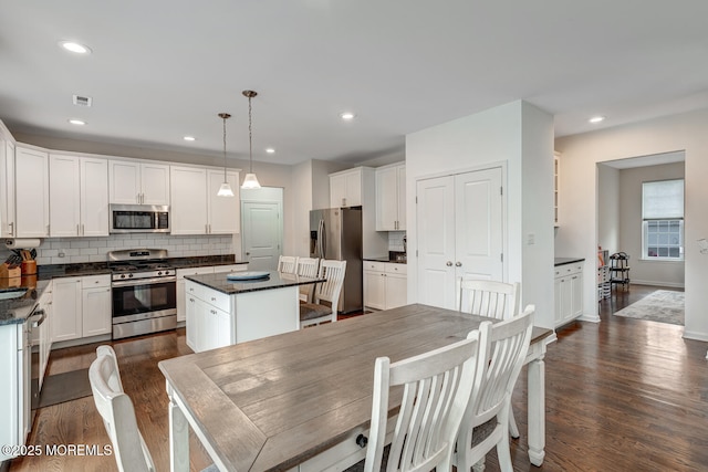 909 Amsterdam Ave, Toms River, NJ 08757 - kitchen featuring stainless steel appliances, dark wood-style flooring, tasteful backsplash, white cabinets, and a kitchen island