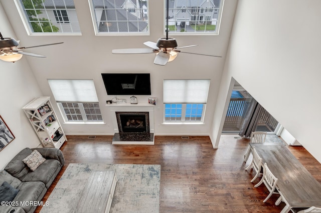 909 Amsterdam Ave, Toms River, NJ 08757 - living room with ceiling fan, wood finished floors, a fireplace, a towering ceiling, and baseboards