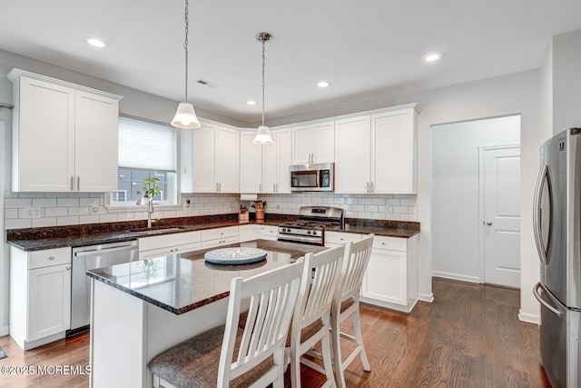 909 Amsterdam Ave, Toms River, NJ 08757 - kitchen with stainless steel appliances, a sink, dark wood-style flooring, white cabinetry, and tasteful backsplash