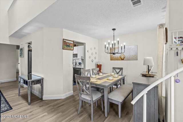 2001 Begonia Ct, Jackson, NJ 08527 - dining area with a chandelier, light wood-type flooring, baseboards, and a textured ceiling