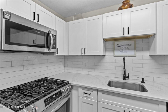 2001 Begonia Ct, Jackson, NJ 08527 - kitchen with appliances with stainless steel finishes, a sink, white cabinets, and decorative backsplash