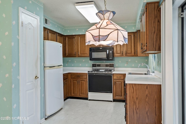 11 Sedgwick Sq, Jackson, NJ 08527 - kitchen with white appliances, a sink, brown cabinets, light countertops, and a textured ceiling