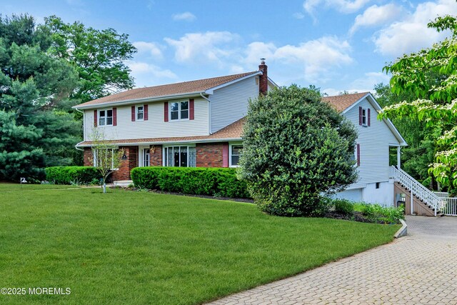 36 Stoney Creek Ln, Colts Neck, NJ 07722 - view of front of home featuring a chimney, a front lawn, decorative driveway, roof with shingles, and brick siding