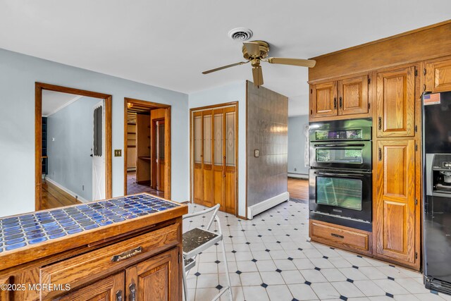 36 Stoney Creek Ln, Colts Neck, NJ 07722 - kitchen featuring tile counters, black appliances, a ceiling fan, baseboards, and brown cabinetry