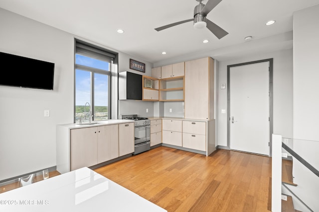 601 Bangs Ave Unit 701, Asbury Park, NJ 07712 - kitchen with stainless steel gas stove, a sink, light wood-style flooring, light countertops, and open shelves