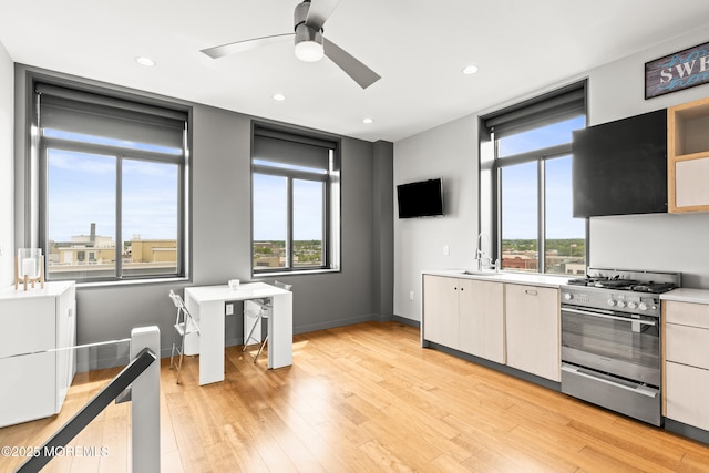 601 Bangs Ave Unit 701, Asbury Park, NJ 07712 - kitchen with gas stove, a sink, a ceiling fan, light countertops, and light wood-style floors