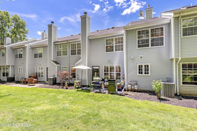 405 Hampton Ct Unit 15-4, Manalapan, NJ 07726 - back of property with a patio area, central AC unit, a yard, and a chimney