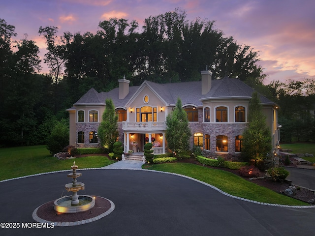6 Bordens Brook Way, Holmdel, NJ 07733 - french country style house featuring stone siding, a balcony, a chimney, and a yard