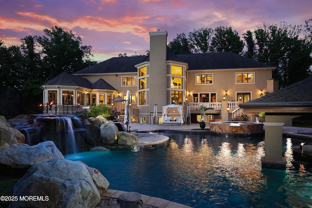 6 Bordens Brook Way, Holmdel, NJ 07733 - rear view of house with a chimney, an in-ground hot tub, an outdoor pool, and stucco siding
