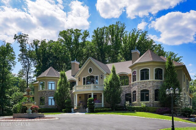 6 Bordens Brook Way, Holmdel, NJ 07733 - view of front facade featuring stone siding, stucco siding, a balcony, and a chimney