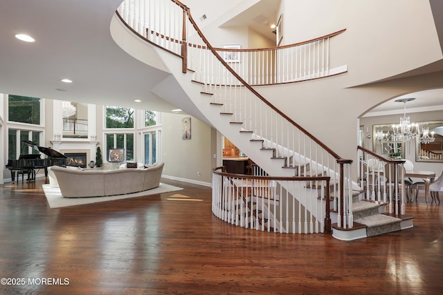 6 Bordens Brook Way, Holmdel, NJ 07733 - stairs with baseboards, wood finished floors, a high ceiling, a chandelier, and a glass covered fireplace