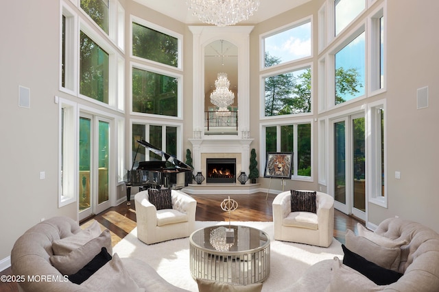 6 Bordens Brook Way, Holmdel, NJ 07733 - living room with a towering ceiling, a chandelier, wood finished floors, a warm lit fireplace, and baseboards
