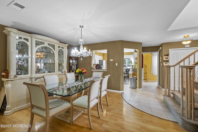33 Oliver Ct Unit 1, Freehold, NJ 07728 - dining room with stairway, a chandelier, light wood finished floors, and baseboards