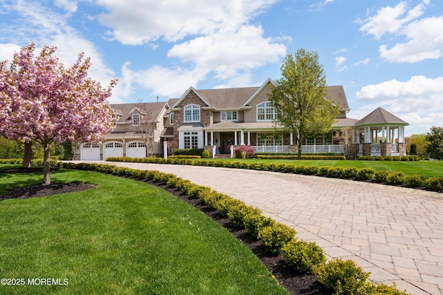 7 Stoney Brook Dr, Millstone, NJ 08510 - shingle-style home with a front lawn, stone siding, a garage, curved driveway, and covered porch