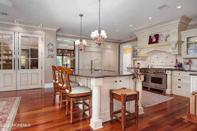 7 Stoney Brook Dr, Millstone, NJ 08510 - kitchen featuring double oven range, a sink, a chandelier, cream cabinets, and crown molding