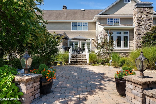 7 Stoney Brook Dr, Millstone, NJ 08510 - rear view of house with a chimney, a wooden deck, a patio area, and roof with shingles