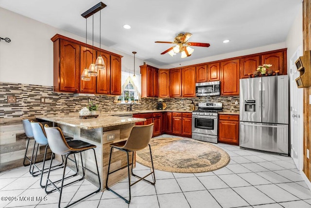 9 Kindling Way, Jackson, NJ 08527 - kitchen featuring appliances with stainless steel finishes, a peninsula, a sink, a ceiling fan, and decorative light fixtures
