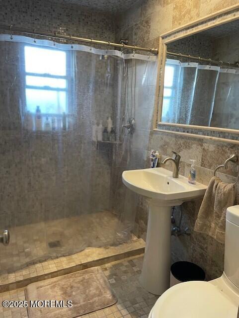310 Maryland Ave Unit 11B, Point Pleasant Beach, NJ 08742 - full bath featuring a stall shower, tile walls, and toilet