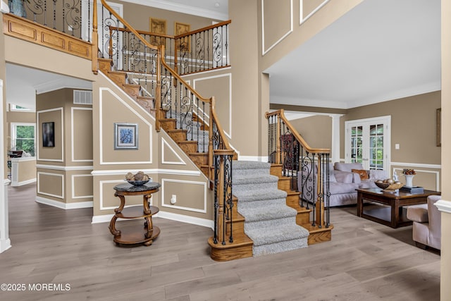 209 Shepard Way, Manalapan, NJ 07726 - stairs with a decorative wall, wood finished floors, crown molding, and a towering ceiling