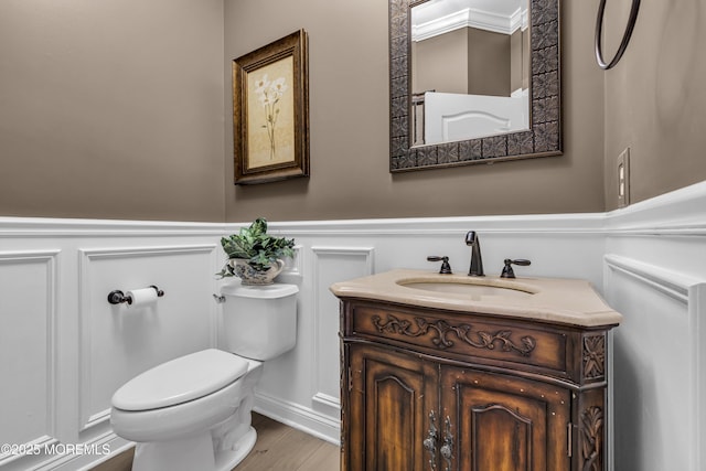 209 Shepard Way, Manalapan, NJ 07726 - bathroom featuring a decorative wall, toilet, vanity, a wainscoted wall, and wood finished floors