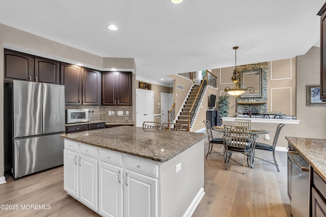 209 Shepard Way, Manalapan, NJ 07726 - kitchen featuring freestanding refrigerator, white microwave, backsplash, baseboards, and dark brown cabinetry
