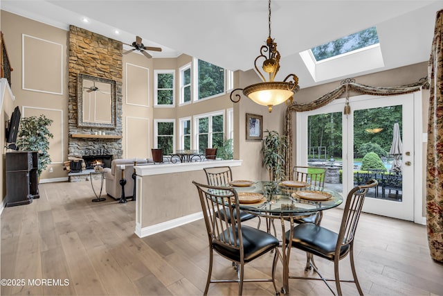 209 Shepard Way, Manalapan, NJ 07726 - dining space featuring a high ceiling, a skylight, light wood-style flooring, a stone fireplace, and recessed lighting