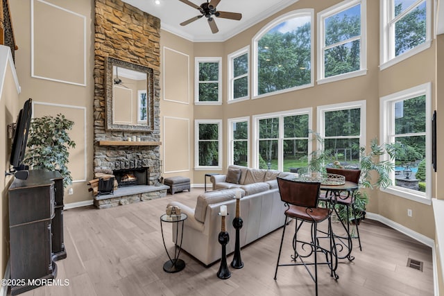 209 Shepard Way, Manalapan, NJ 07726 - living room featuring a ceiling fan, plenty of natural light, a stone fireplace, crown molding, and baseboards