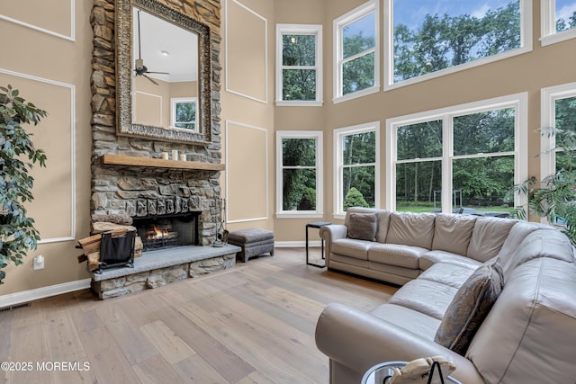 209 Shepard Way, Manalapan, NJ 07726 - living room featuring baseboards, ceiling fan, a fireplace, a high ceiling, and hardwood / wood-style flooring
