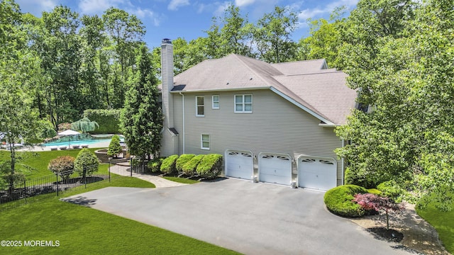 209 Shepard Way, Manalapan, NJ 07726 - view of side of home featuring a chimney, asphalt driveway, an attached garage, and roof with shingles