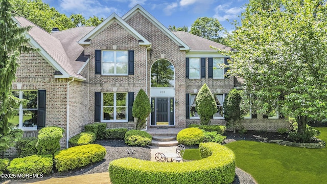 209 Shepard Way, Manalapan, NJ 07726 - view of front facade with brick siding, a shingled roof, and a front yard