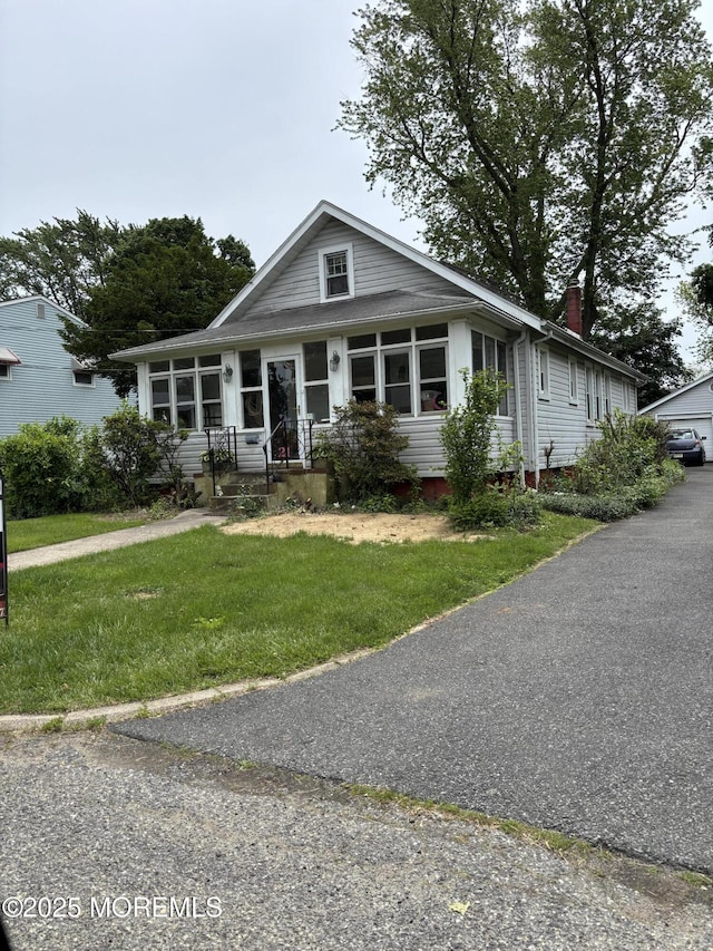21 Alexander Ave, Freehold, NJ 07728 - view of front facade with a chimney and a front lawn