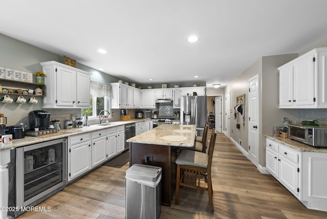 6 Overlook Dr, Jackson, NJ 08527 - kitchen with beverage cooler, a sink, white cabinets, tasteful backsplash, and appliances with stainless steel finishes