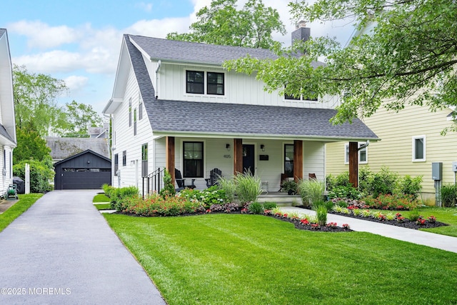 405 Ludlow Ave, Spring Lake, NJ 07762 - view of front facade featuring an outbuilding, a porch, a detached garage, a chimney, and a front lawn