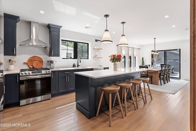 405 Ludlow Ave, Spring Lake, NJ 07762 - kitchen featuring gas stove, wall chimney range hood, light wood finished floors, light countertops, and recessed lighting