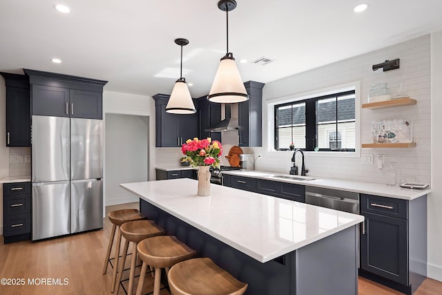 405 Ludlow Ave, Spring Lake, NJ 07762 - kitchen with stainless steel appliances, a sink, decorative backsplash, light wood-type flooring, and a breakfast bar