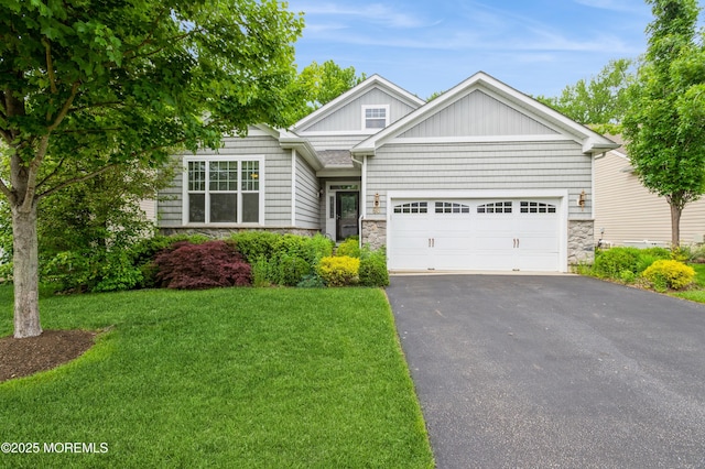 63 Wintergreen Dr, Manalapan, NJ 07726 - view of front of property featuring stone siding, asphalt driveway, an attached garage, and a front yard