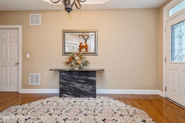 63 Wintergreen Dr, Manalapan, NJ 07726 - entrance foyer with a chandelier, wood finished floors, and baseboards