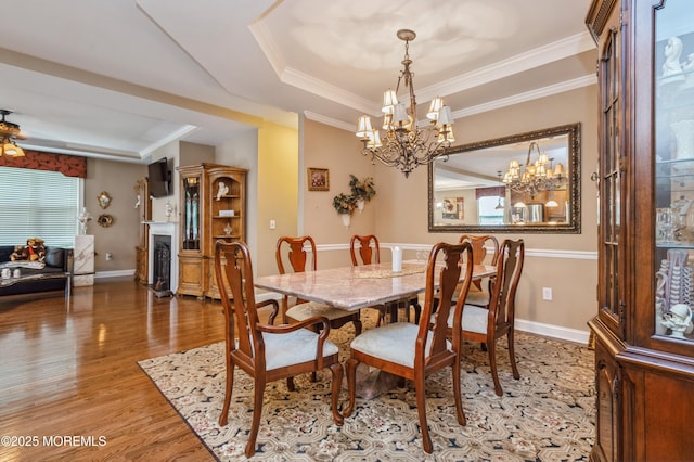 63 Wintergreen Dr, Manalapan, NJ 07726 - dining room featuring a chandelier, a tray ceiling, wood finished floors, ornamental molding, and baseboards