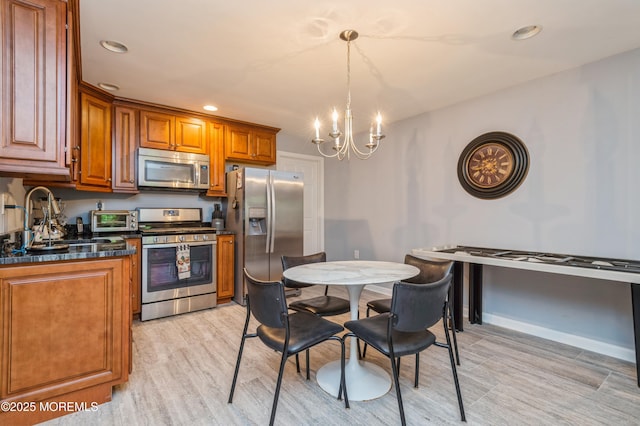 63 Wintergreen Dr, Manalapan, NJ 07726 - kitchen featuring stainless steel appliances, light wood finished floors, a chandelier, brown cabinets, and dark countertops