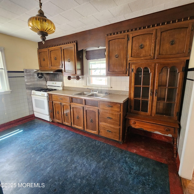 2102 Princeton Pike, Lawrence, NJ 08648 - kitchen featuring white gas range, brown cabinets, a sink, light countertops, and tile walls