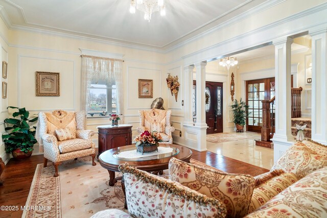 304 8th Ave, Belmar, NJ 07719 - living area with decorative columns, a chandelier, a decorative wall, crown molding, and wood finished floors