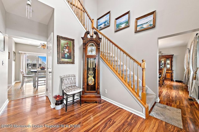 128 E Delaware Dr, Little Egg Harbor, NJ 08087 - stairs featuring wood finished floors, baseboards, a towering ceiling, and a ceiling fan